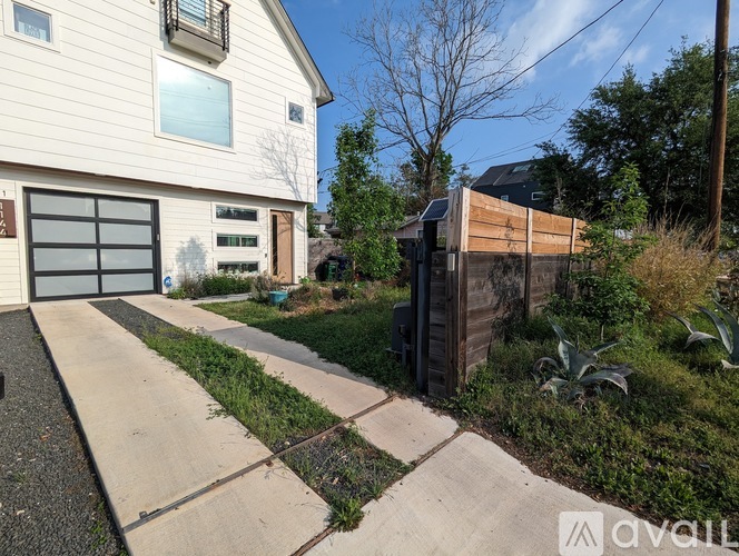 A house with a garage and a driveway in front of it.