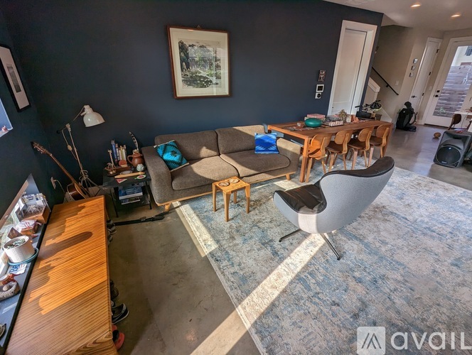A living room with a grey couch, a wooden coffee table, and a blue rug.
