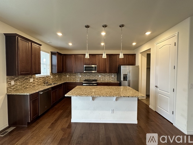 A kitchen with brown cabinets and a granite countertop.