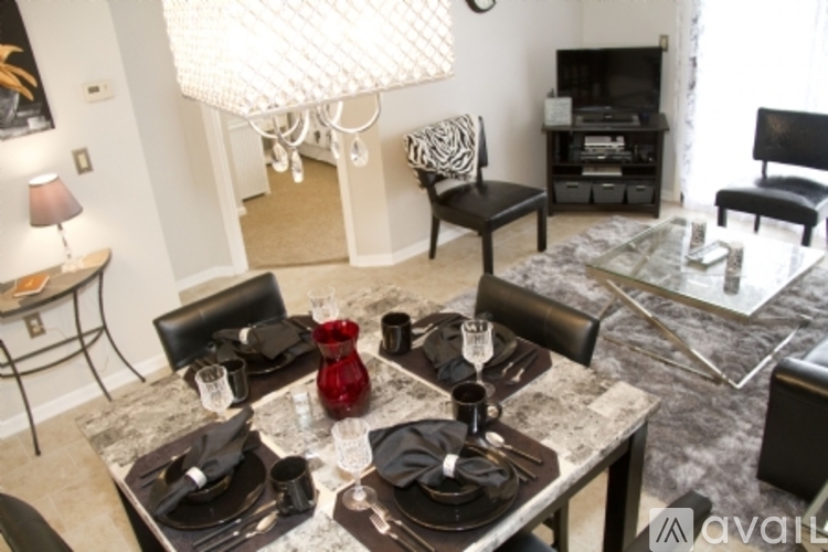 A modern dining room with a marble table and black chairs.