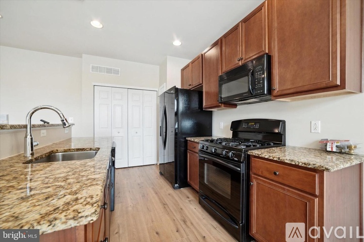 A kitchen with wooden cabinets and black appliances.