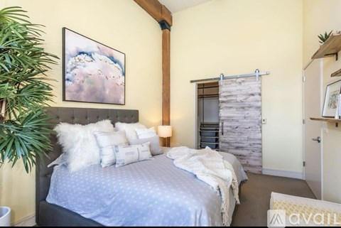 A bedroom with a large bed and a painting on the wall.