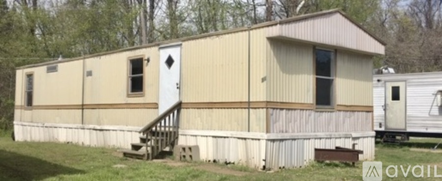 A beige mobile home with a white door and a small porch.