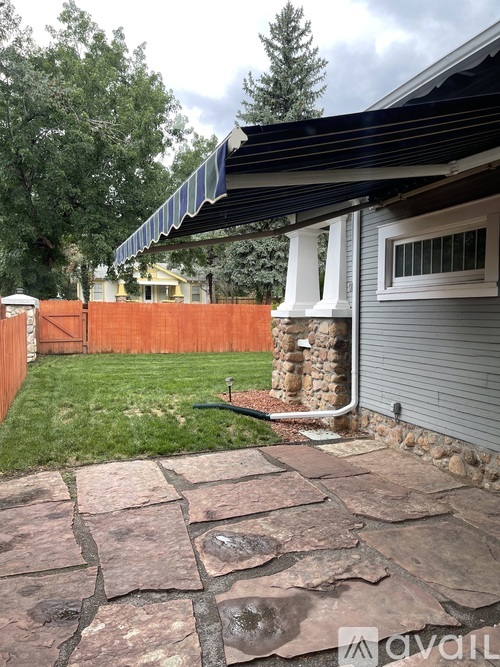 A patio with a stone walkway leads to a house.
