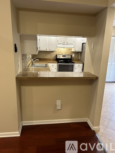 A kitchen with white cabinets and a granite countertop.
