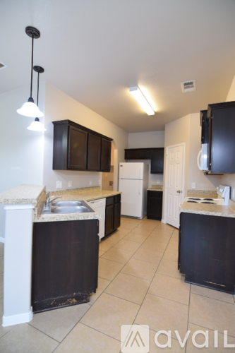 A kitchen with black cabinets and a white counter.