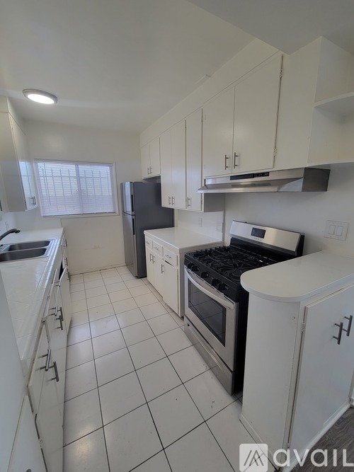 A kitchen with white cabinets and appliances.