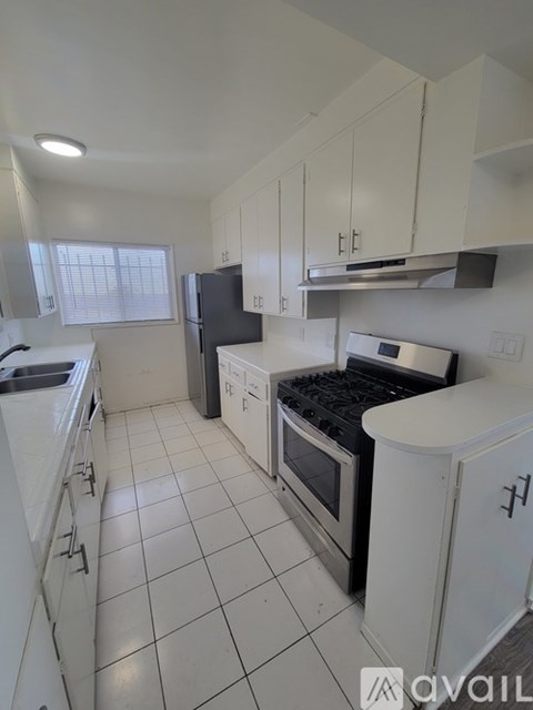 A kitchen with white cabinets and appliances.