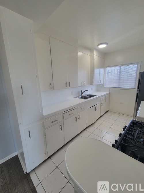 A kitchen with white cabinets and a sink.