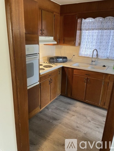A kitchen with wooden cabinets and a white oven.