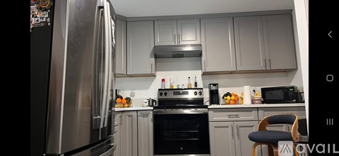 A kitchen with a stainless steel refrigerator and a black oven.