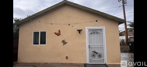 A small house with a white door and a butterfly decoration.