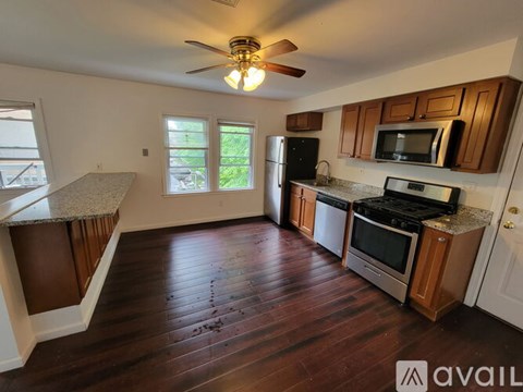 A kitchen with wooden cabinets and a black refrigerator.