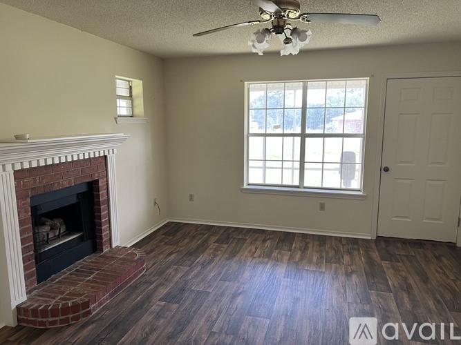 A room with a fireplace and a ceiling fan.