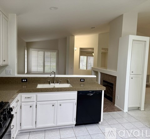A kitchen with white cabinets and a granite countertop.