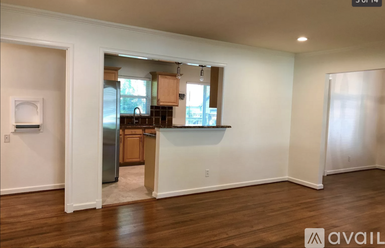 A kitchen with white walls and wooden floors is available for rent.