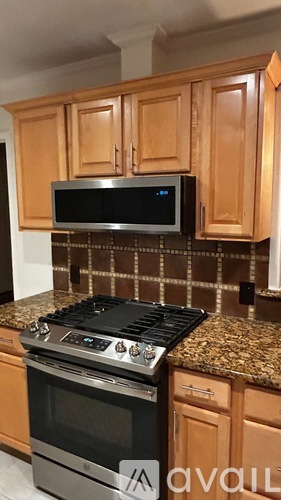 A kitchen with wooden cabinets and a black stove top oven.