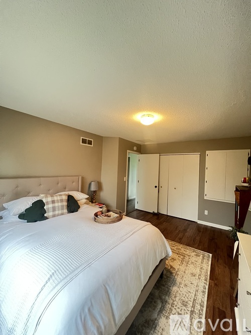 A bedroom with a large bed and a wooden floor.