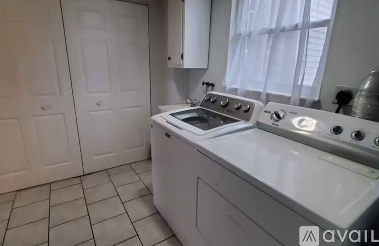 A white kitchen with a stove top oven and a dishwasher.
