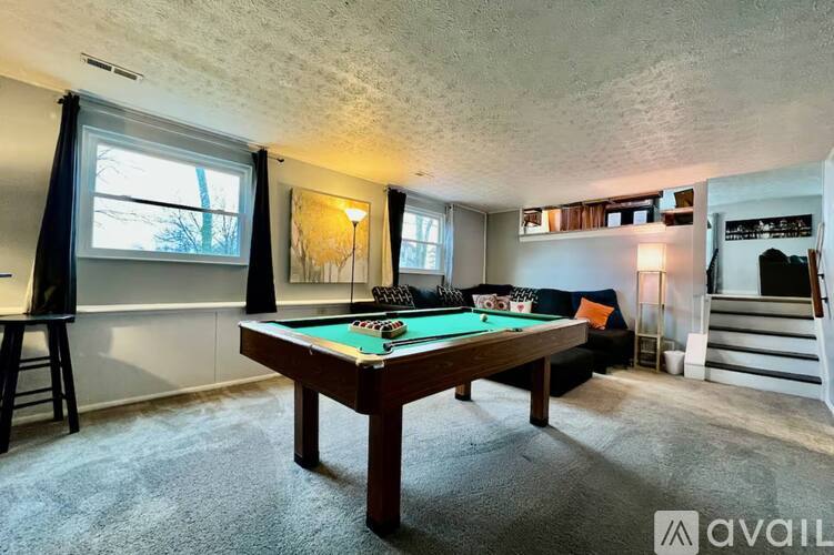 A room with a pool table and a painting on the wall.