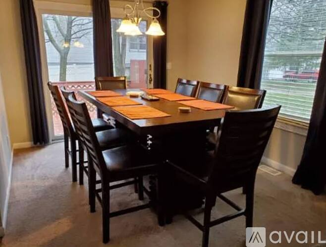 A dining room with a large table and chairs.