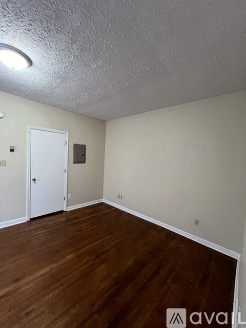 A room with wooden floors and a white door.