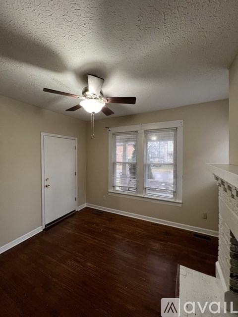 A room with a ceiling fan and a fireplace.