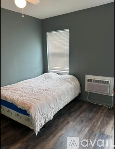 A bedroom with a bed and a small heater unit.