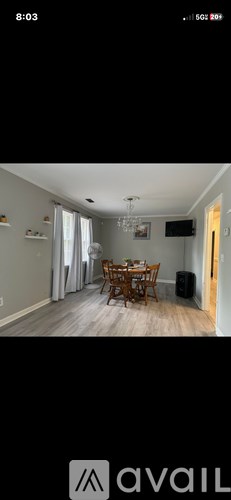 A dining room with a wooden table and chairs.