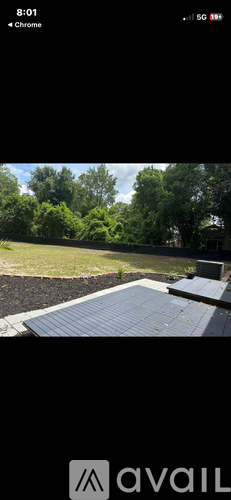 A backyard with a wooden deck and a grassy area.