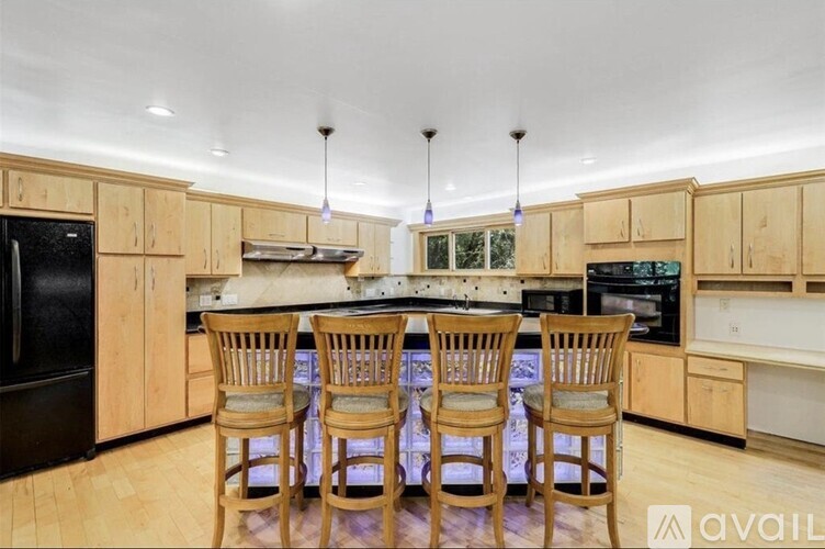 A kitchen with wooden chairs and cabinets.