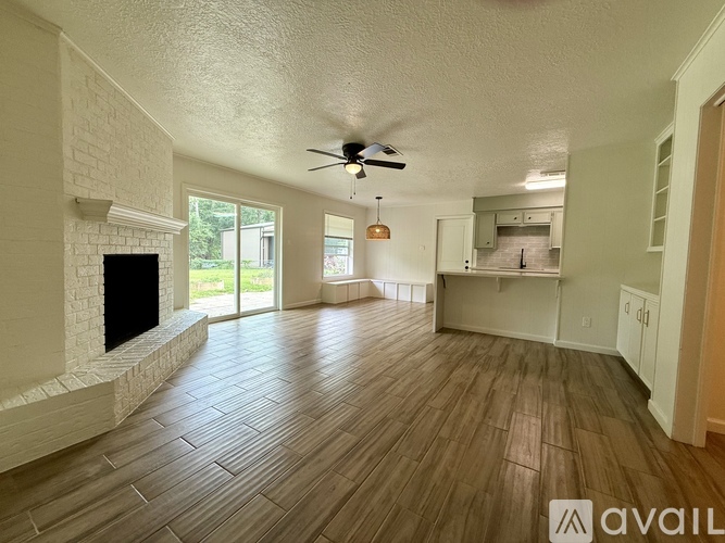 A spacious living room with a fireplace and hardwood flooring.