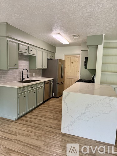 A kitchen with wooden floors and a white counter top.