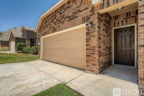 A brick house with a beige garage door and a brown door.