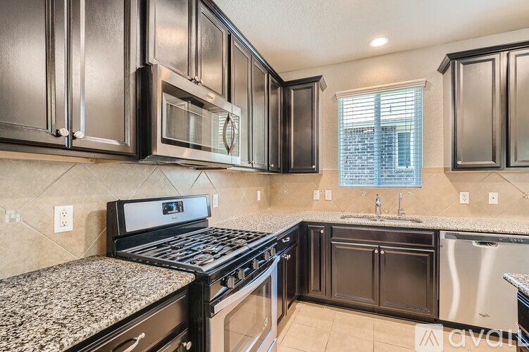 A kitchen with black cabinets and stainless steel appliances.