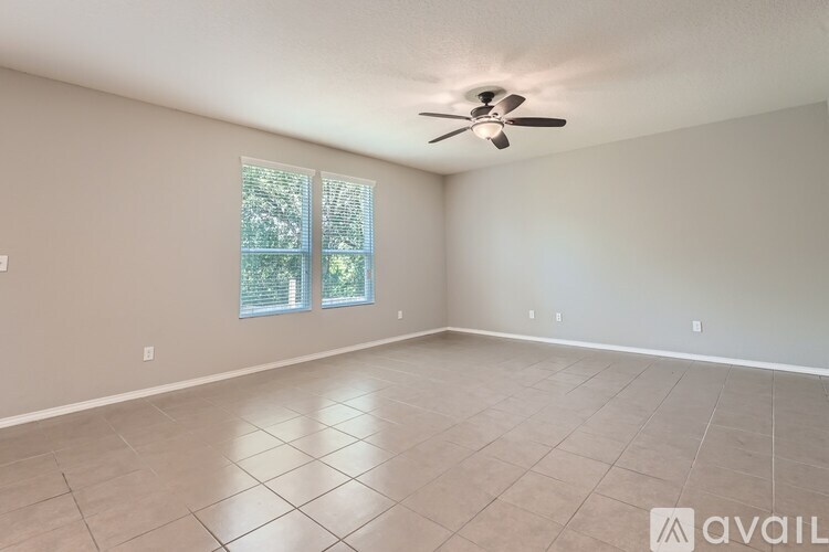 A spacious room with a ceiling fan and a window.