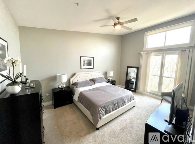 A bedroom with a bed, dresser, and television.