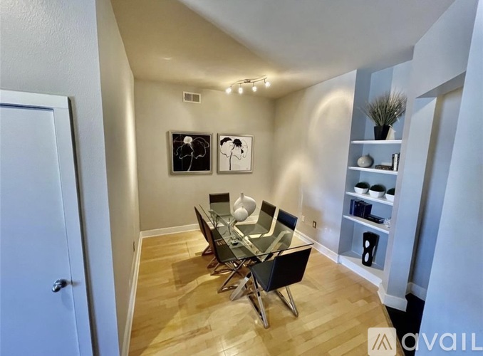 A dining room with a glass table and chairs.