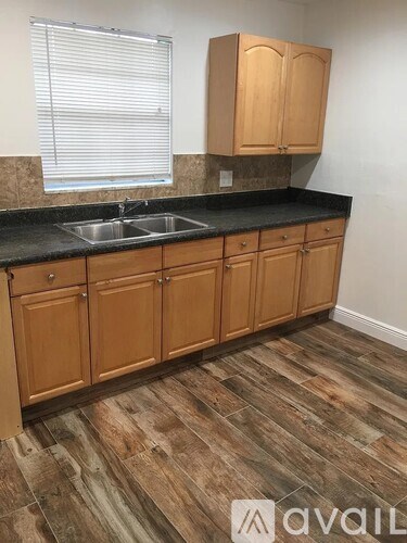 A kitchen with wooden cabinets and a black countertop.