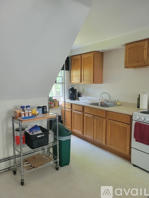A kitchen with wooden cabinets and a white stove.