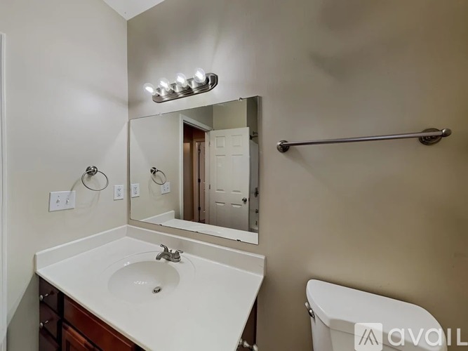 A bathroom with a sink, mirror, and towel rack.