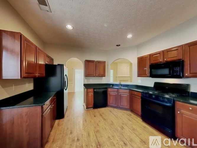 A kitchen with wooden cabinets and black appliances.