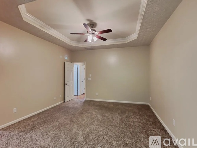 A room with a ceiling fan and carpeted floor.
