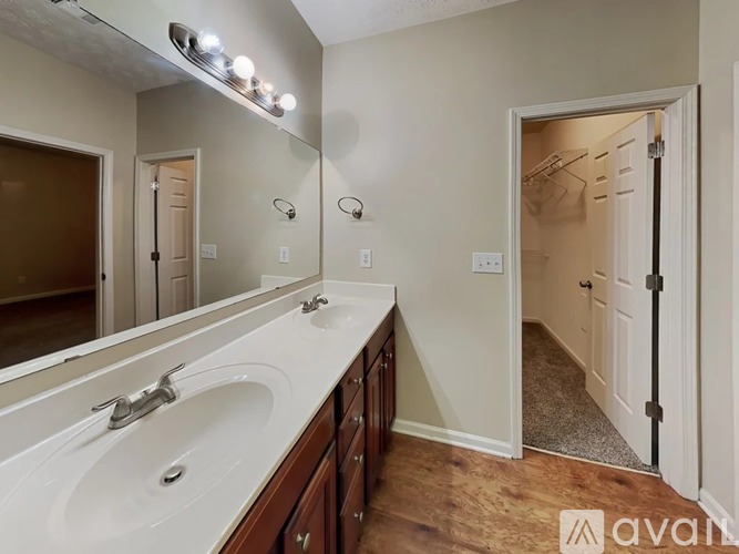 A bathroom with a white sink and a mirror above it.