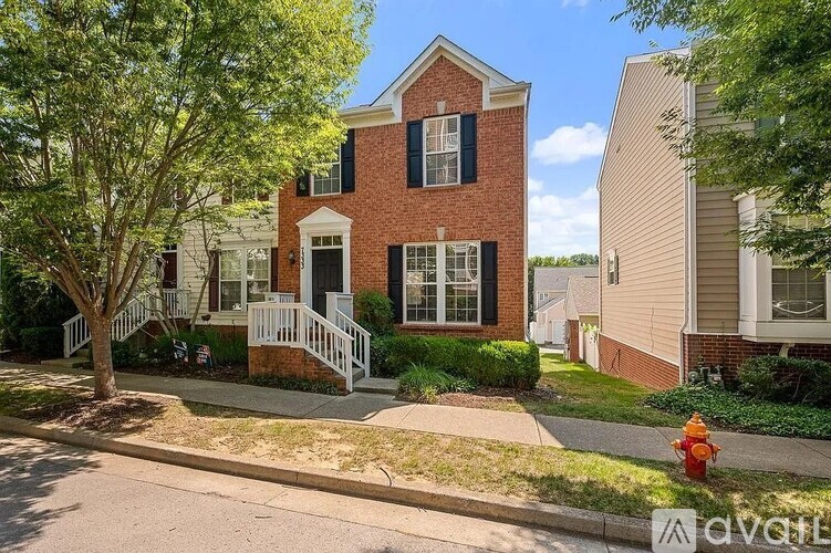 A house with a red brick facade and a white porch.