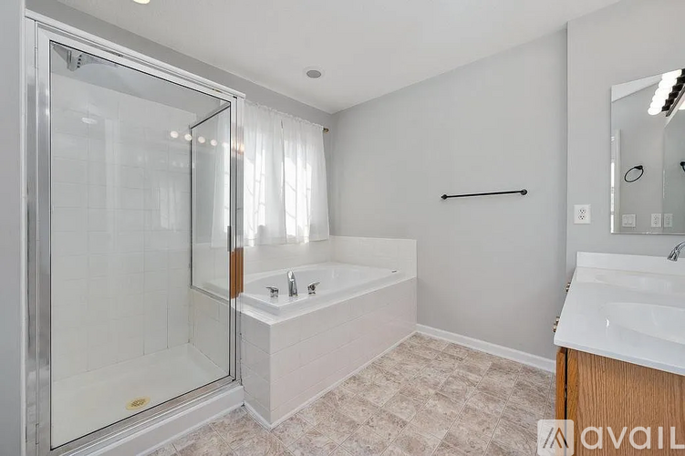 A bathroom with a glass shower door, a bathtub, and a sink.