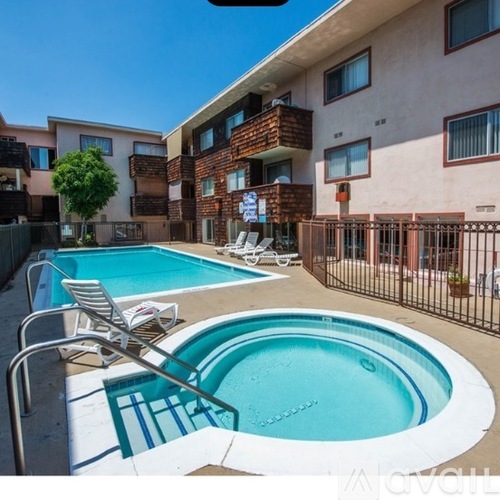 A swimming pool with a chair and a table in front of a building.