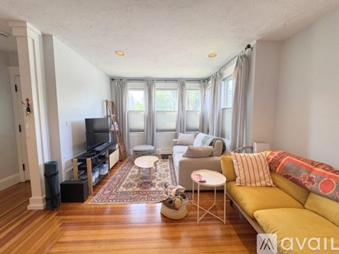 A living room with a yellow couch and a television.