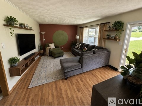 A living room with a grey couch and a green chair.