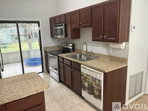 A kitchen with brown cabinets and a granite countertop.